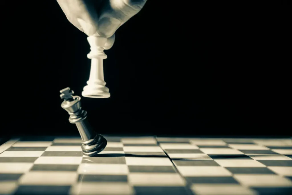 A dramatic checkmate moment as a white king knocks over the black king on a chessboard